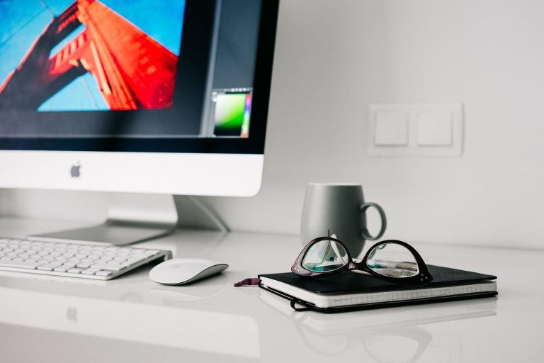 Stylish blue light blocking glasses on a desk.
